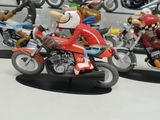 two figurines of people riding motorcycles on display