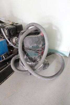 un aspirateur posé par terre à côté d'un ordinateur
