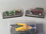 three toy cars in a clear box on a table
