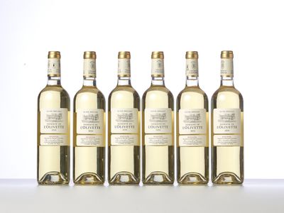 six bottles of white wine are lined up on a table