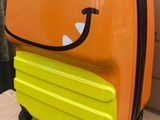 une valise sur laquelle est dessiné un visage souriant, posée sur un carton