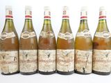 six bouteilles de vin posées les unes à côté des autres sur une surface blanche