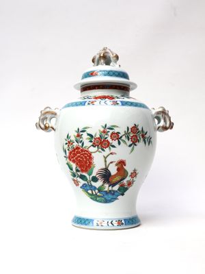 a white vase with a bird and flowers on it