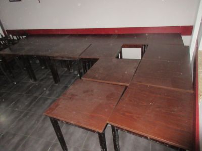des tables et des chaises dans une pièce aux murs rouges et au sol carrelé
