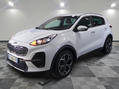 a white car is parked on a checkered floor in a garage