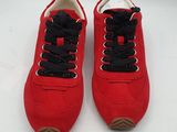 une paire de baskets rouges avec des lacets noirs sur un fond blanc