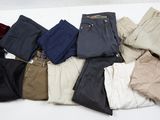 plusieurs paires de pantalons pour homme disposées sur une surface blanche