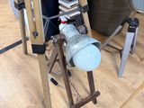 a wooden easel with a lamp on top of it in a room