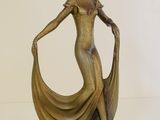bronze statue of a woman with a flowing dress on a base