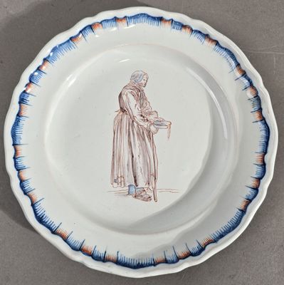 une assiette sur laquelle est représentée une femme tenant un panier