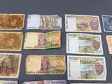many different bank notes laid out on a table