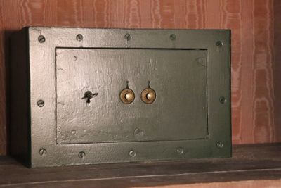a small metal safe box on a shelf in a room