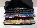 a black bag filled with markers and pens on a table