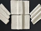 Plusieurs serviettes blanches sont disposées sur une surface noire