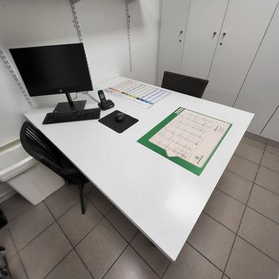 un bureau sur lequel se trouvent un ordinateur, un clavier, une souris et un calendrier