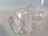two empty glass vases sitting on the floor