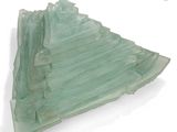 a glass sculpture of a mountain on a white surface