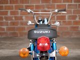 a blue motorcycle parked in front of a brick wall