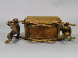 bronze figurine of a man and woman with a box on a table