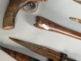 many different types of weapons displayed on a table