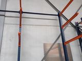 a picture of a rack in a warehouse with orange handles