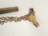 a brass chain with a brass key attached to it