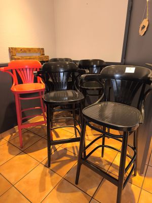 de nombreuses chaises et tabourets dans un coin de la pièce