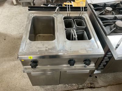 two stainless steel fryers and a stove in a kitchen