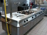 a large stainless steel kitchen with a stove and oven