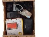 une boîte en carton contenant un appareil photo, un téléphone portable et d'autres objets