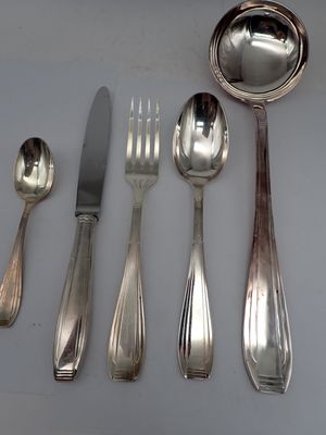 five silver spoons and two silver spoons on a table