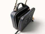 the small black bag is sitting on a white surface with a chain around it