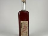 a small bottle of liquor sitting on top of a white table