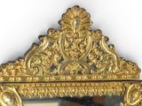 a mirror with a gold frame on the wall