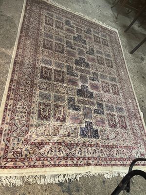 un tapis posé à même le sol, avec une chaise, et une autre chaise à l'arrière-plan