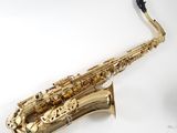 a gold saxophone sitting on top of a white surface
