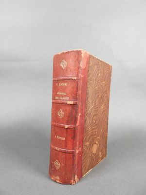 un vieux livre rouge posé sur une surface grise