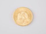 a close up of a gold coin on a white surface