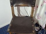 a wooden chair with a leather seat in a room