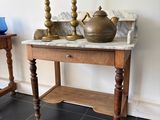 une petite table sur laquelle se trouvent deux bougies et un vase