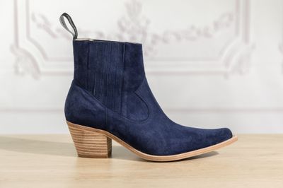 a pair of blue sued ankle boots on a wooden table