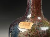 a vase with a tag on it sitting on a table