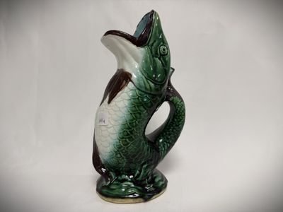 a green and white vase with a fish on it
