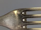 a fork with a metal handle on a gray surface