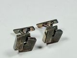 pair of silver cufflinks with mother of pearl in the middle