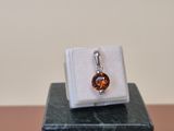 an image of a ring with a brown stone on top of a marble block