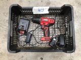 un petit panier posé par terre, contenant des outils