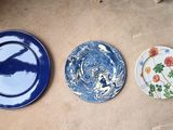 trois assiettes posées par terre les unes à côté des autres