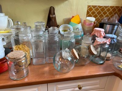 de nombreux bocaux en verre sur le plan de travail de la cuisine