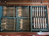 many forks and spoons in a drawer on the table
